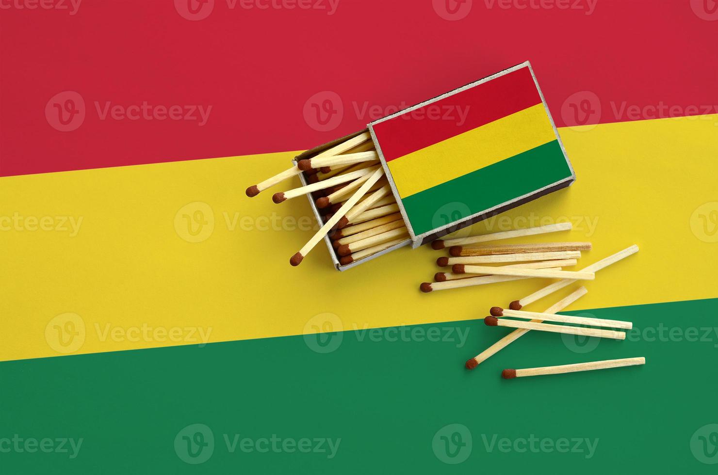 Bolivia flag  is shown on an open matchbox, from which several matches fall and lies on a large flag photo