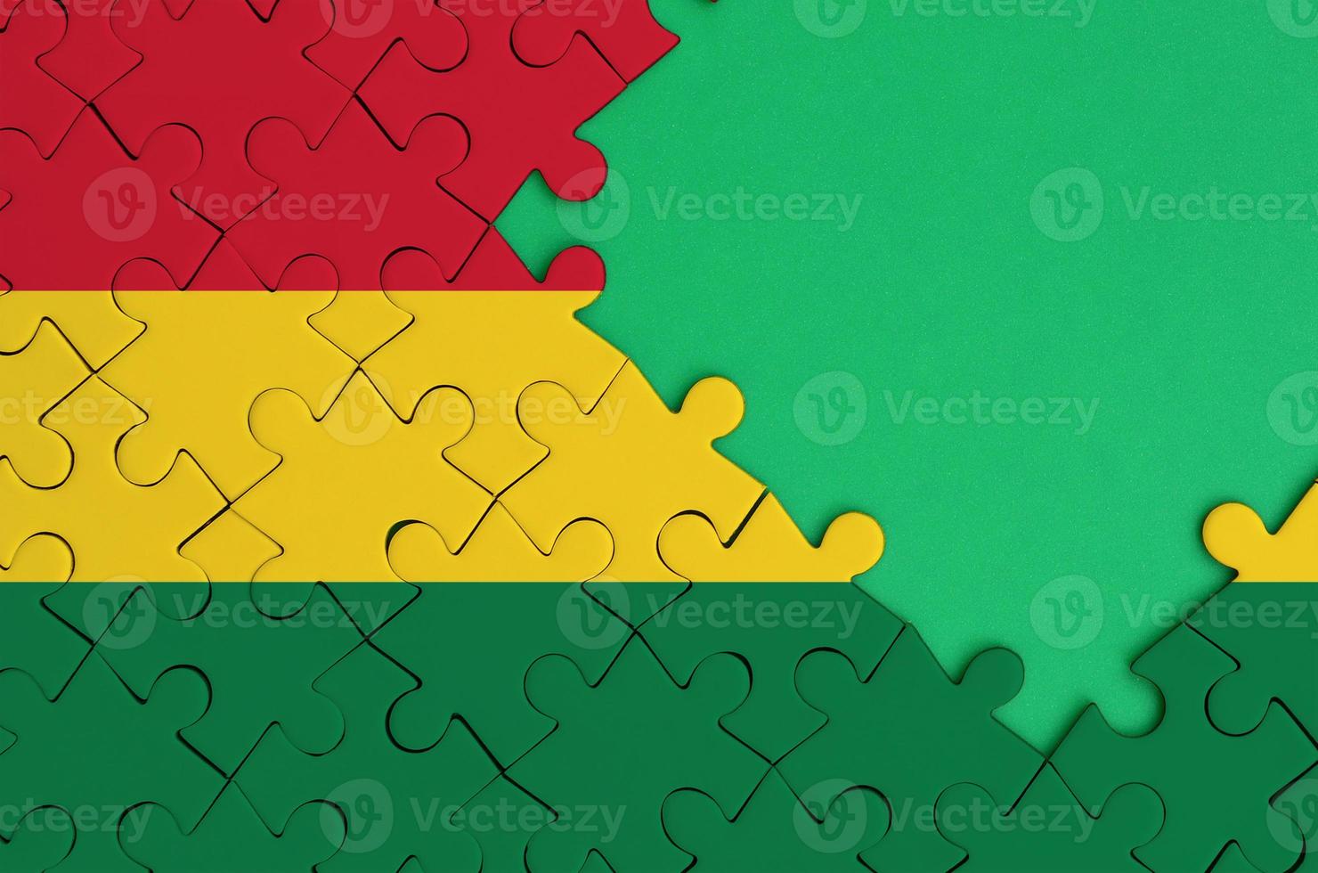Bolivia flag  is depicted on a completed jigsaw puzzle with free green copy space on the right side photo