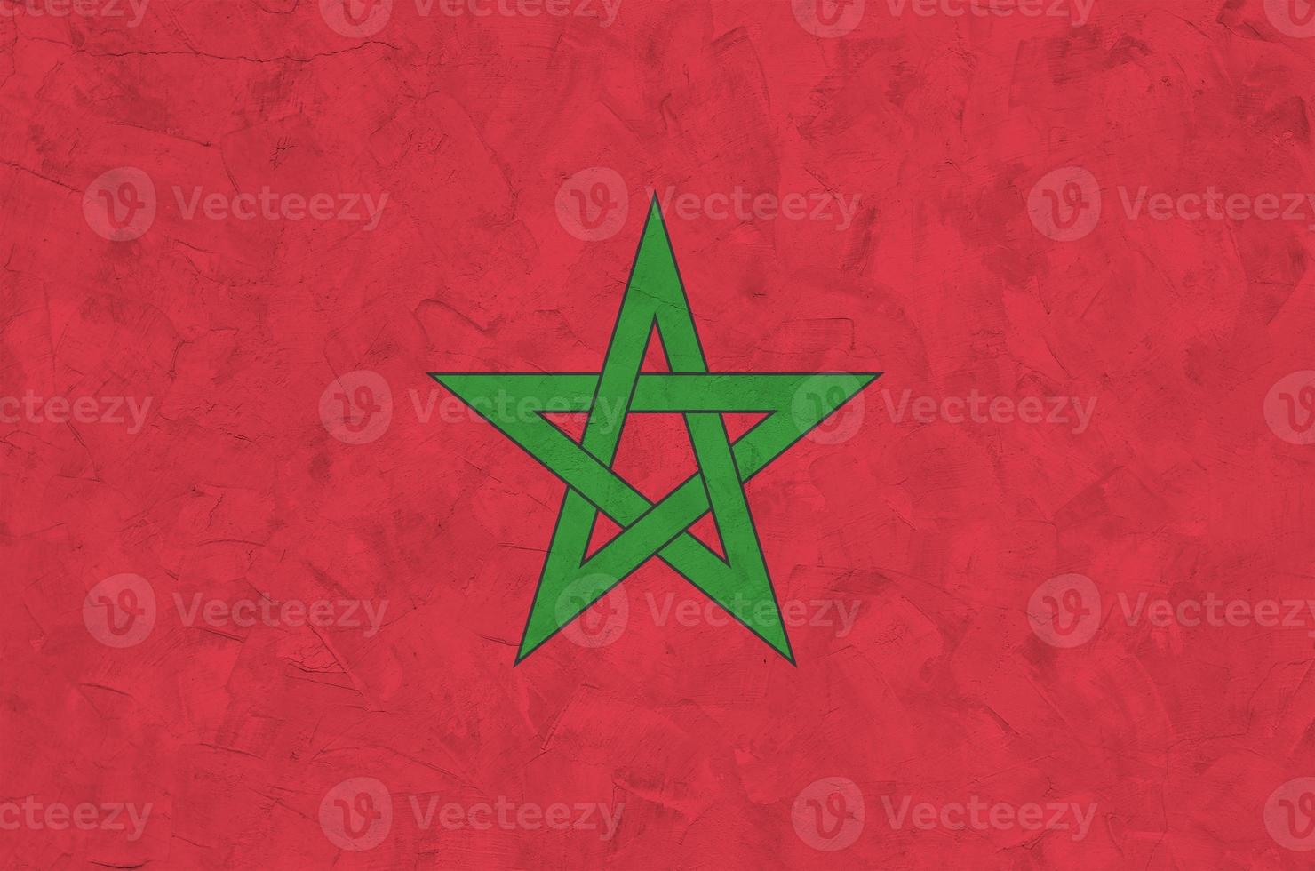 Morocco flag depicted in bright paint colors on old relief plastering wall. Textured banner on rough background photo