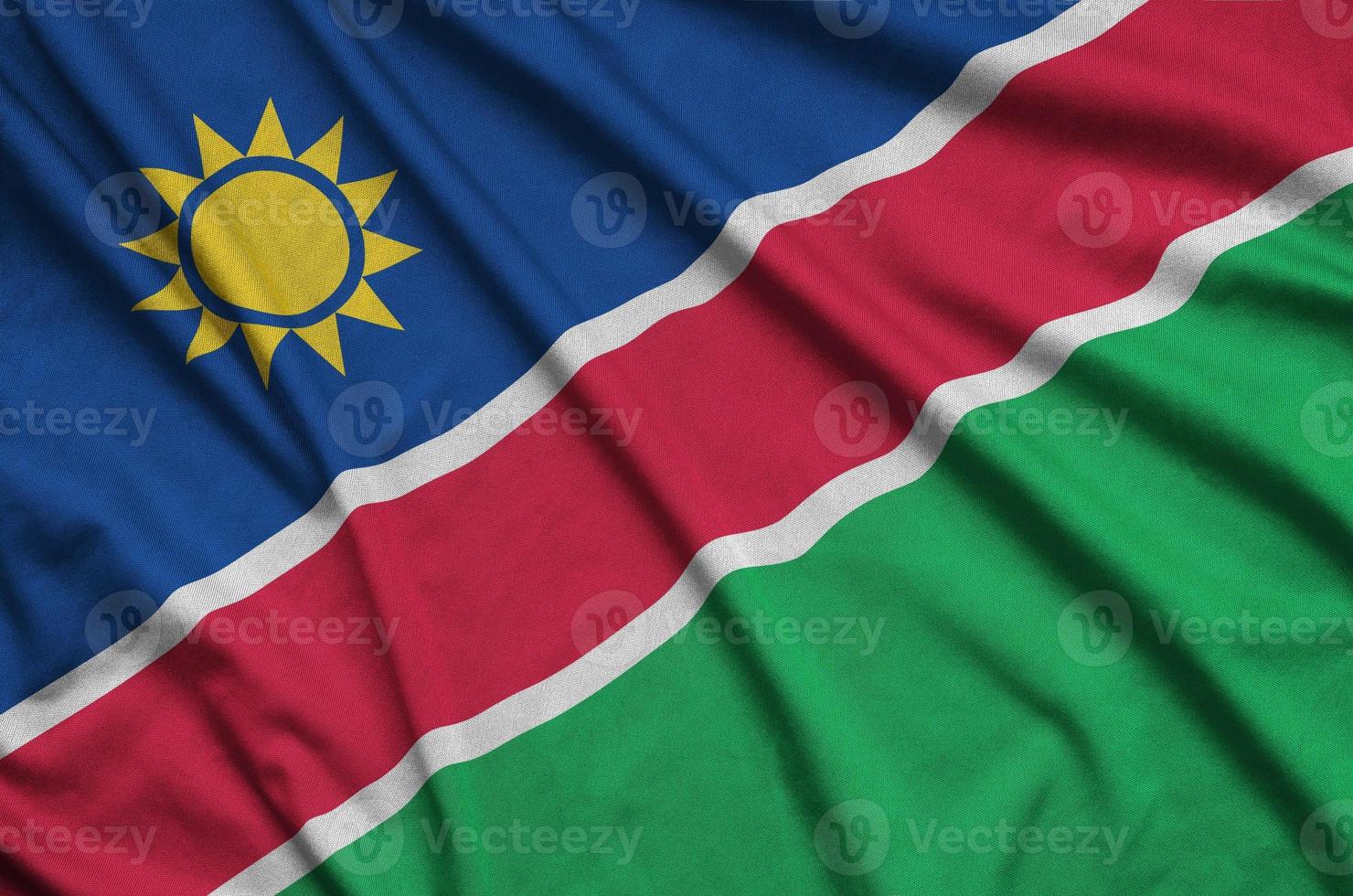 Namibia flag  is depicted on a sports cloth fabric with many folds. Sport team banner photo
