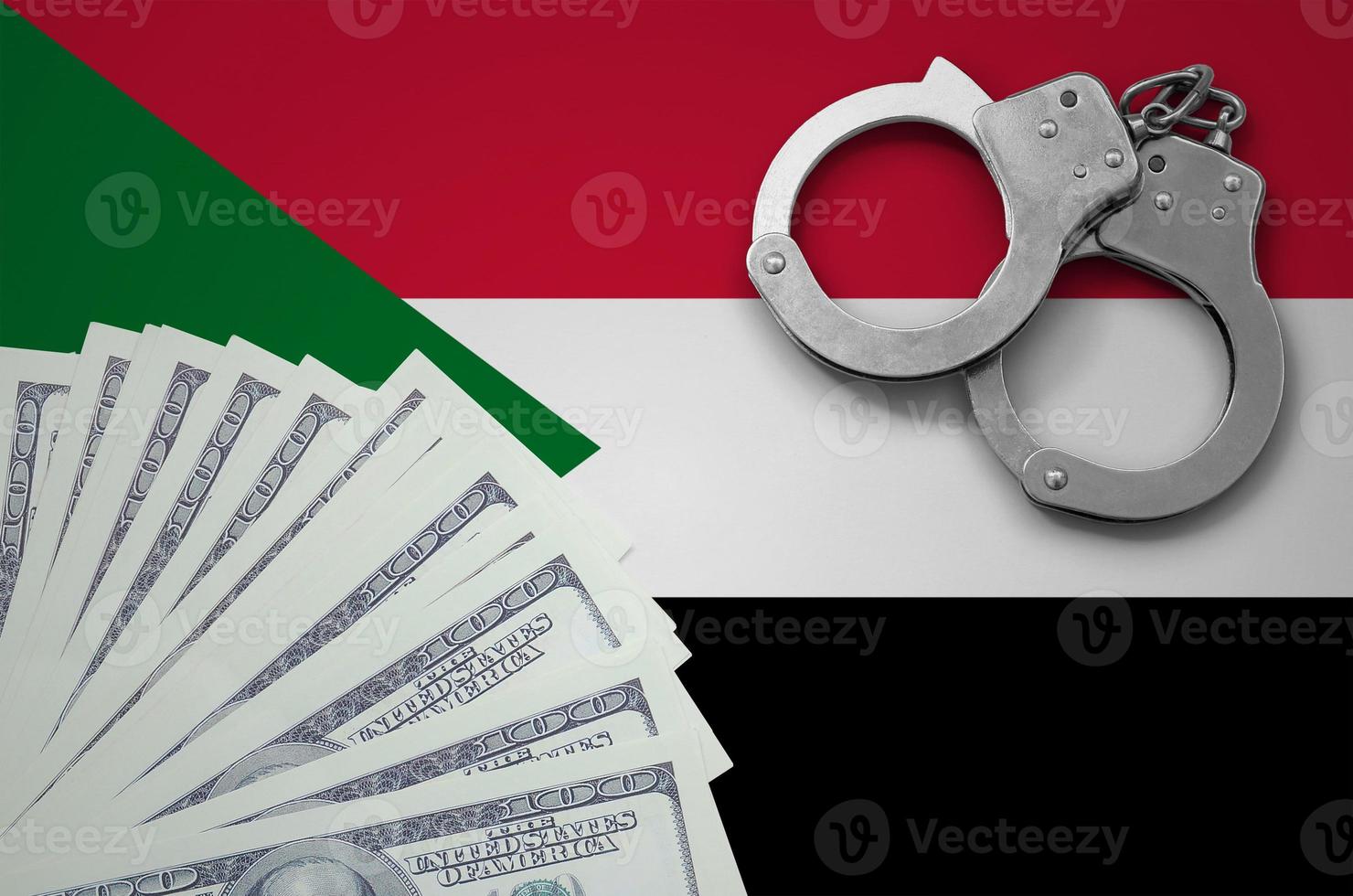 Sudan flag  with handcuffs and a bundle of dollars. The concept of illegal banking operations in US currency photo