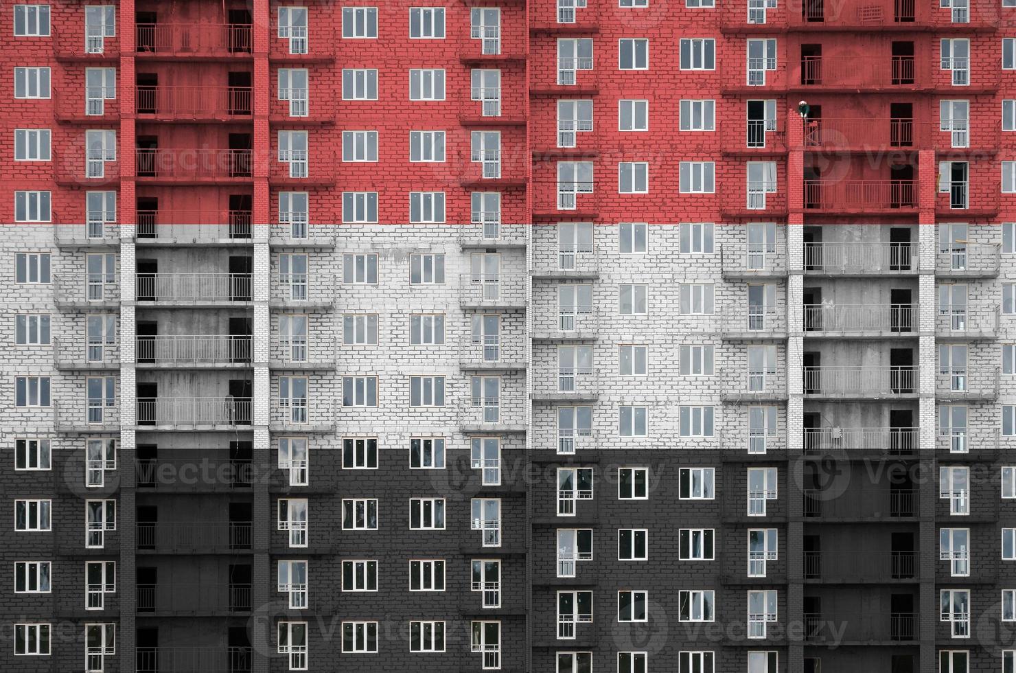 Yemen flag depicted in paint colors on multi-storey residental building under construction. Textured banner on brick wall background photo