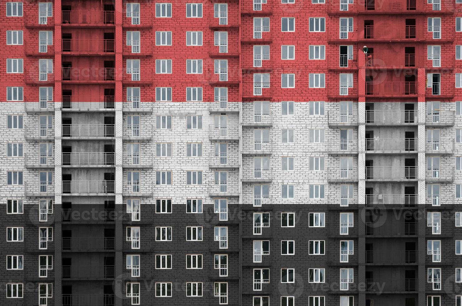 bandera de yemen representada en colores de pintura en un edificio residencial de varios pisos en construcción. banner texturizado sobre fondo de pared de ladrillo foto