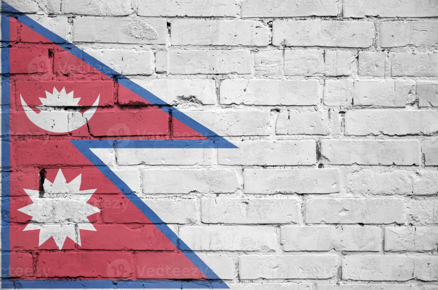 Nepal flag is painted onto an old brick wall photo