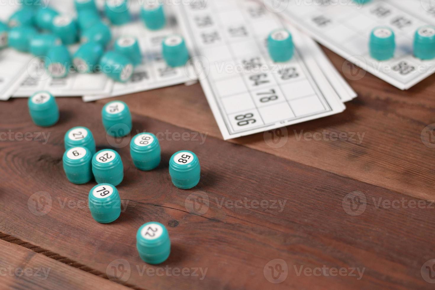 Many barrels with numbers and cards for lotto or russian bingo table game on wooden surface. Russian lotto has similar rules to classical worldwide bingo photo