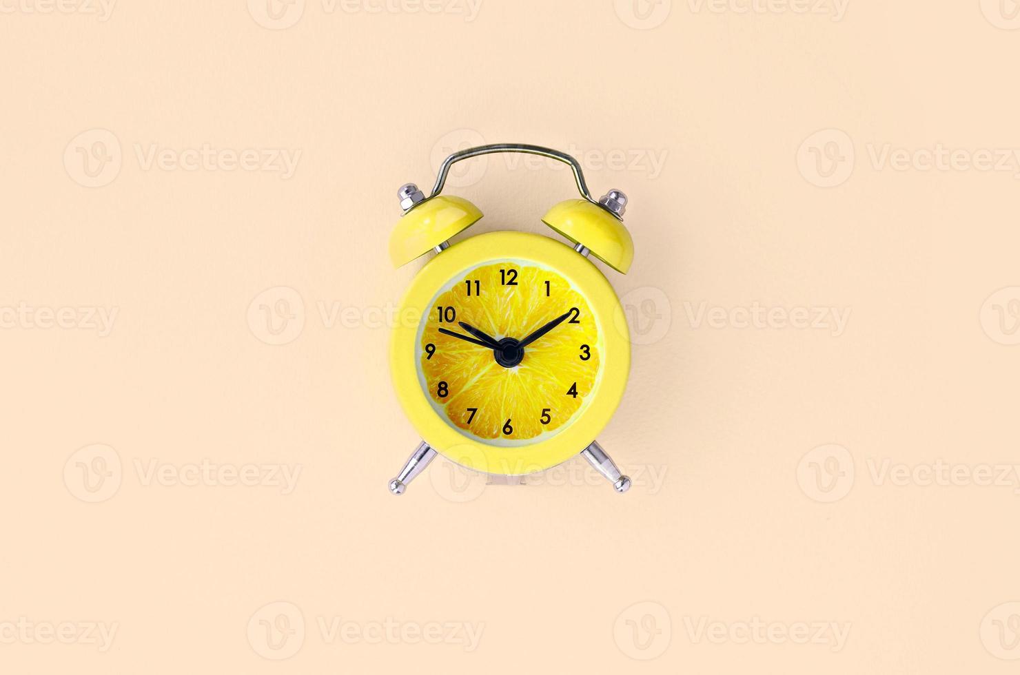 Fresh lemon slice in small yellow alarm clock photo