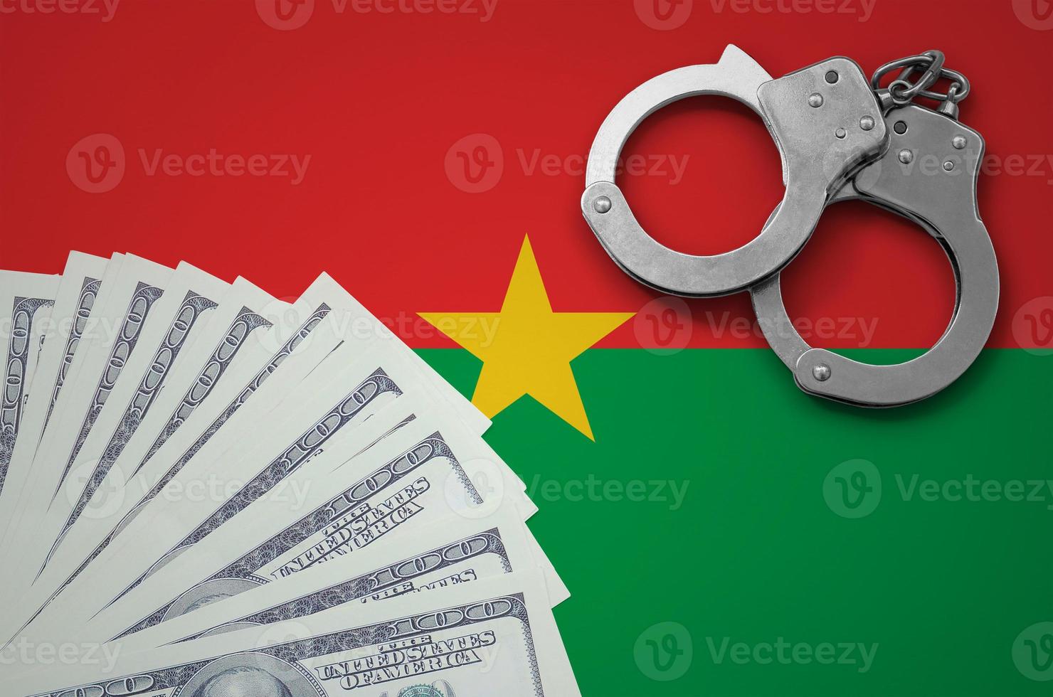 Burkina Faso flag with handcuffs and a bundle of dollars. The concept of illegal banking