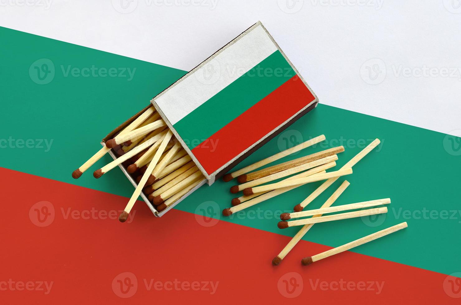 Bulgaria flag  is shown on an open matchbox, from which several matches fall and lies on a large flag photo