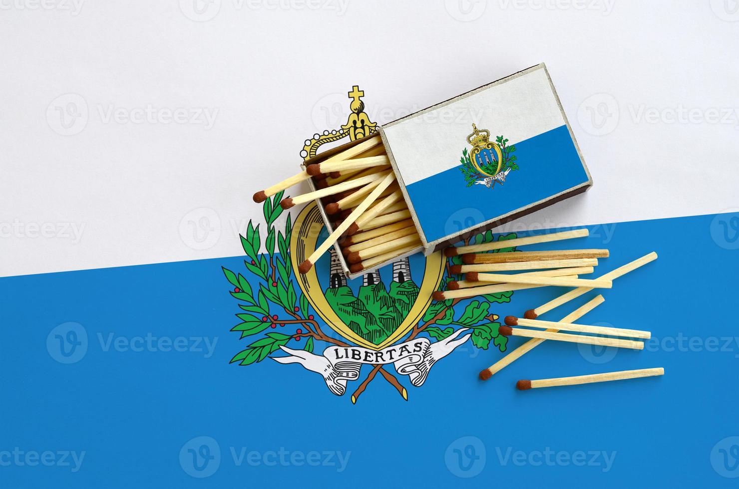 San Marino flag  is shown on an open matchbox, from which several matches fall and lies on a large flag photo
