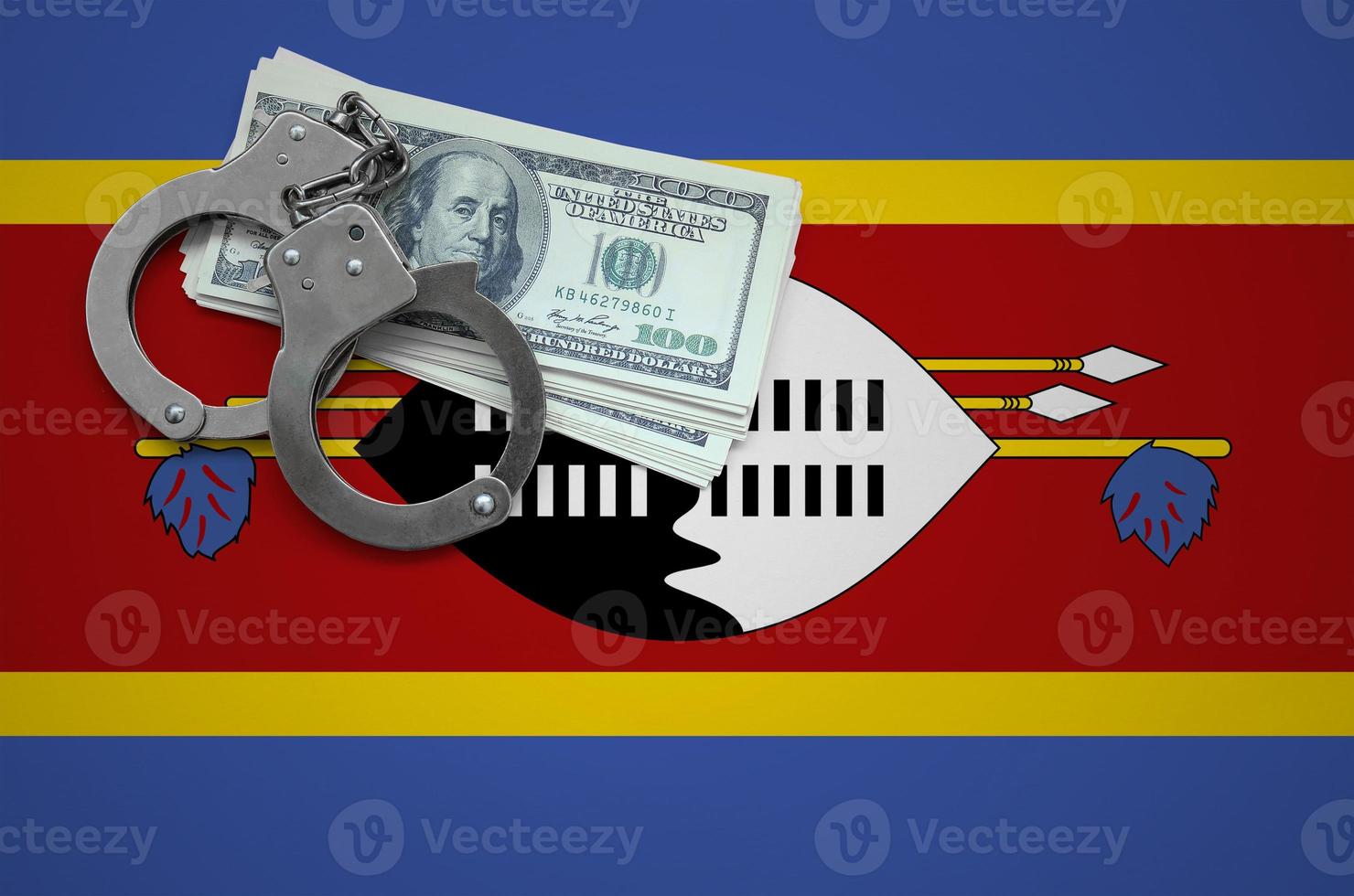 Swaziland flag  with handcuffs and a bundle of dollars. The concept of breaking the law and thieves crimes photo