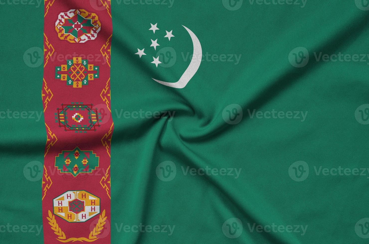 Turkmenistan flag  is depicted on a sports cloth fabric with many folds. Sport team banner photo