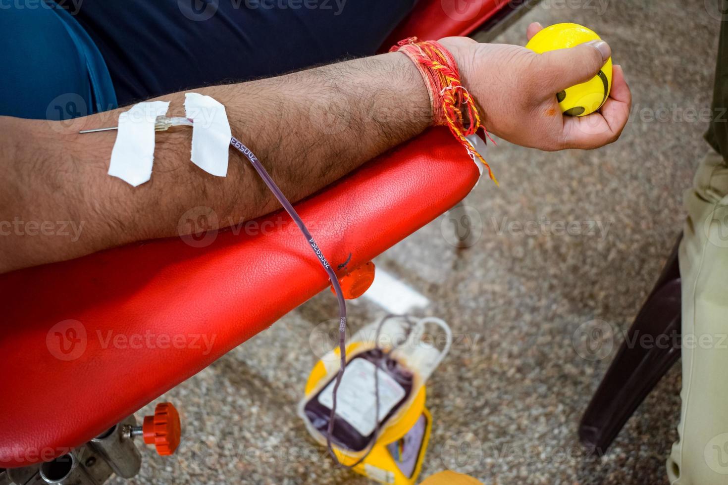 Blood donor at Blood donation camp held with a bouncy ball holding in hand at Balaji Temple, Vivek Vihar, Delhi, India, Image for World blood donor day on June 14 every year, Blood Donation Camp photo