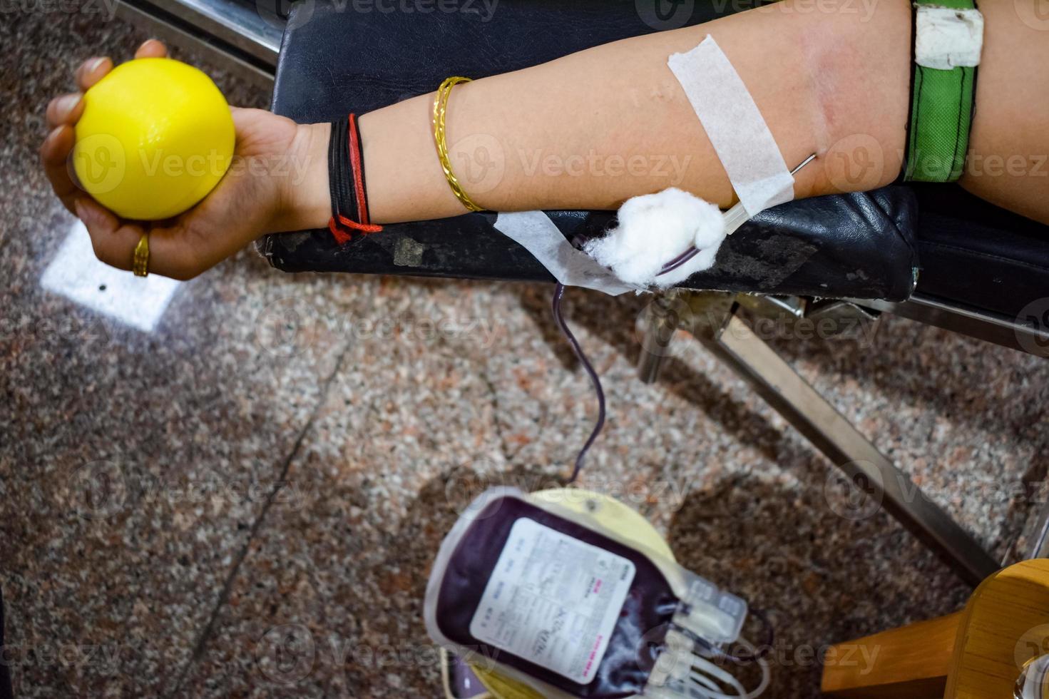 Blood donor at Blood donation camp held with a bouncy ball holding in hand at Balaji Temple, Vivek Vihar, Delhi, India, Image for World blood donor day on June 14 every year, Blood Donation Camp photo