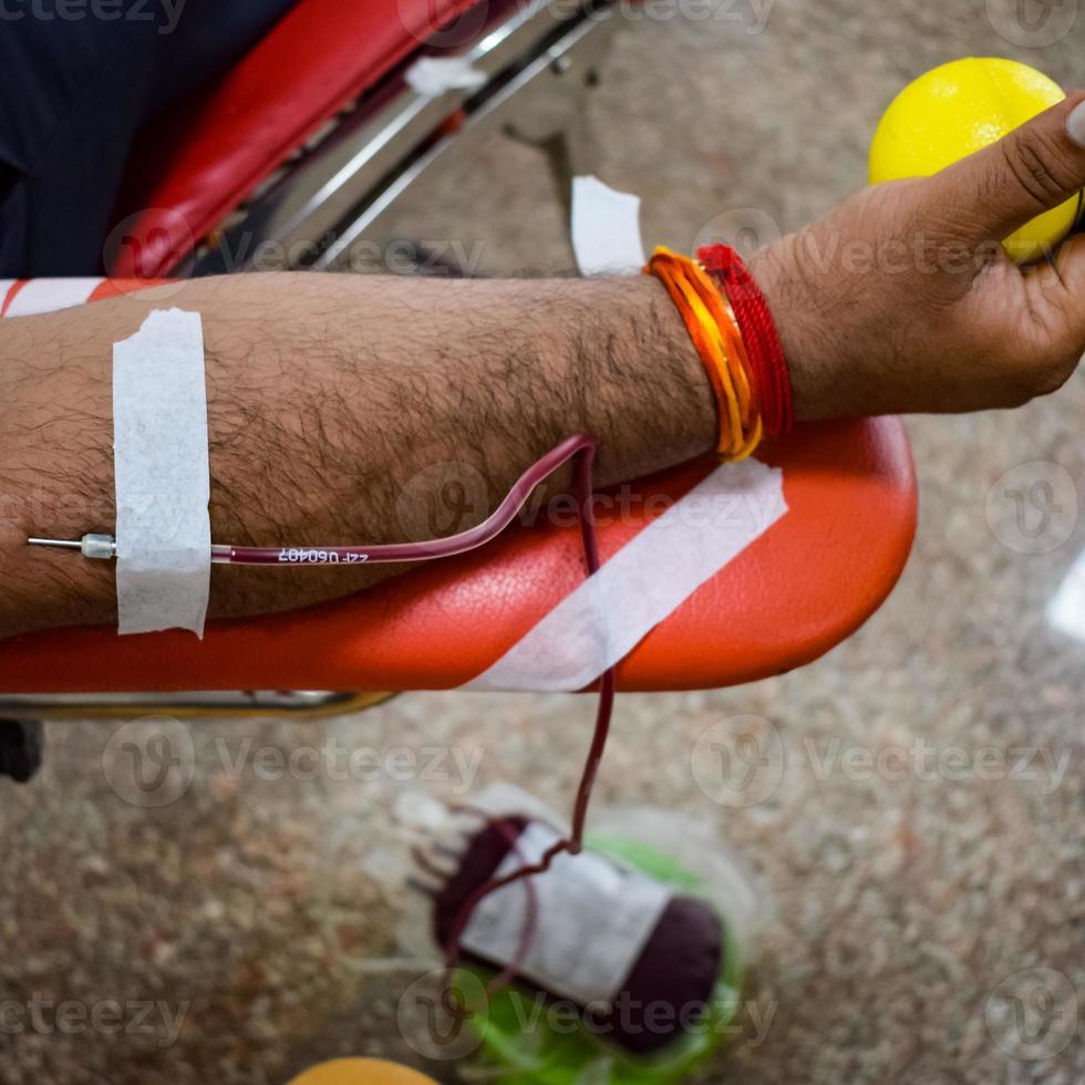 donante de sangre en el campamento de donación de sangre sostenido con una pelota hinchable en la mano en el templo balaji, vivek vihar, delhi, india, imagen para el día mundial del donante de sangre el 14 de junio de cada año, campamento de donación de sangre foto