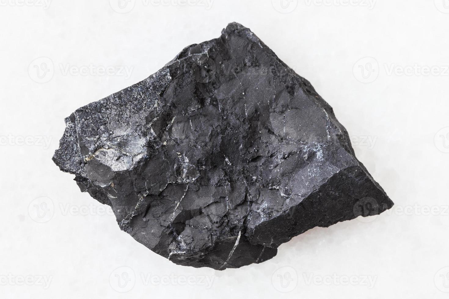 piedra de esquisto de shungite áspera en blanco foto