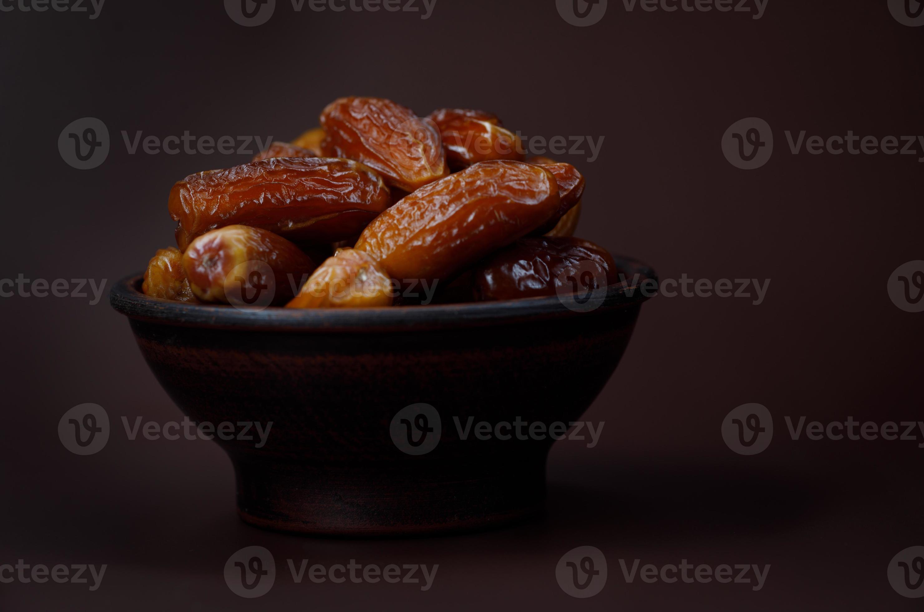 Ripe dried dates in a clay cup on a brown background. 13282554 Stock Photo at Vecteezy