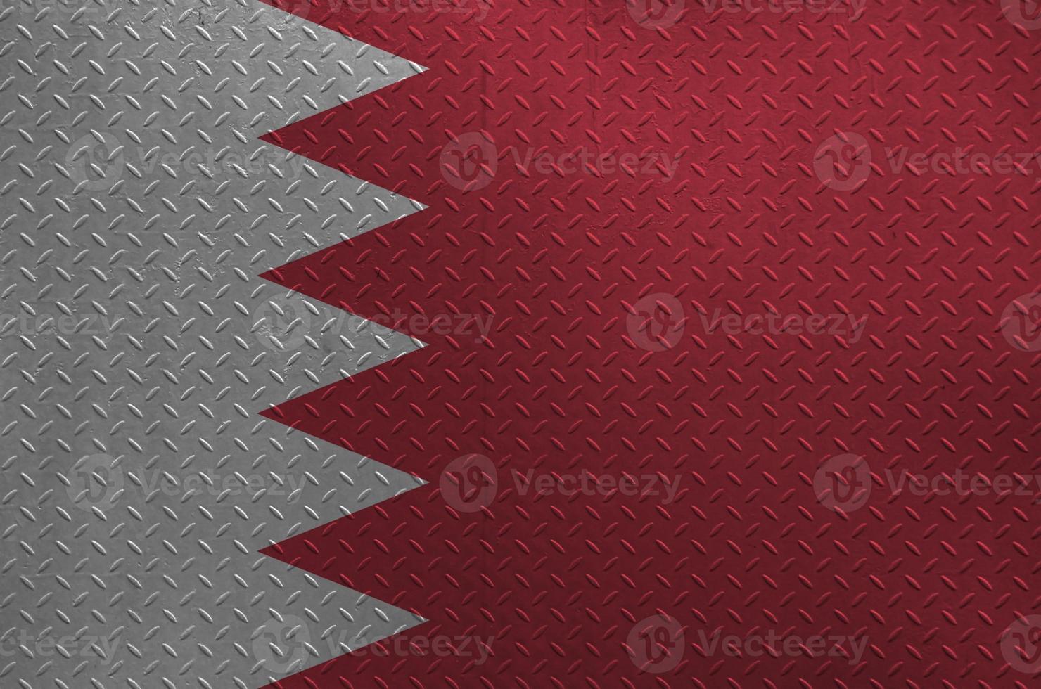 Bahrain flag depicted in paint colors on old brushed metal plate or wall closeup. Textured banner on rough background photo