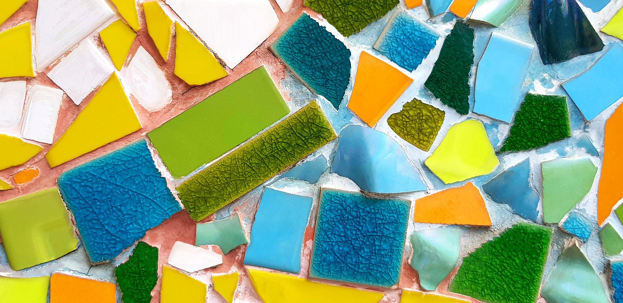 Colorful of mosaic tile floor for background. Art design wallpaper, Cracked, Shape and Abstract. Green, yellow, blue, white and orange tile fragments on wall. photo