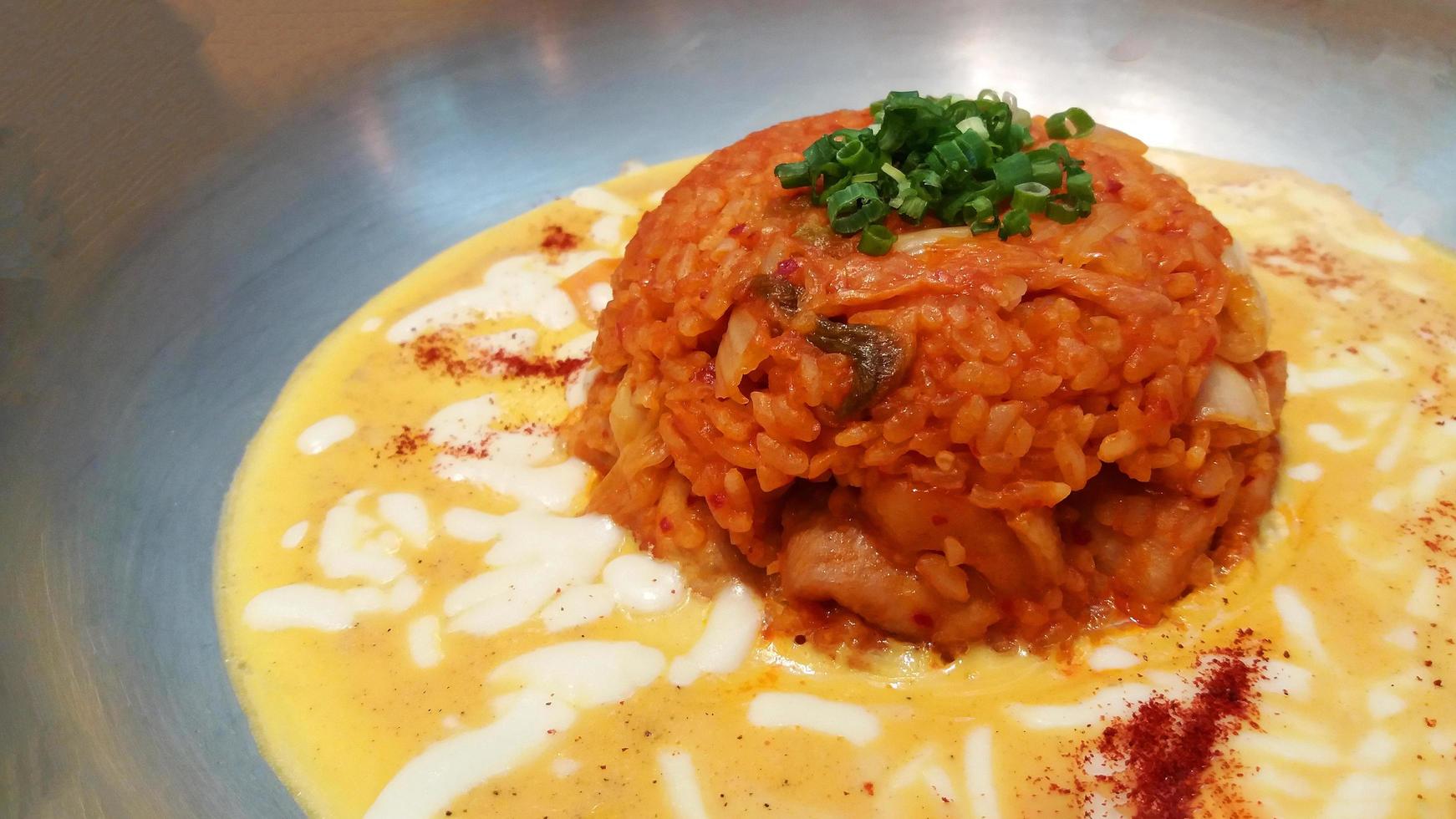 Close up fried kimchi rice with egg and cream cheese sauce on stainless