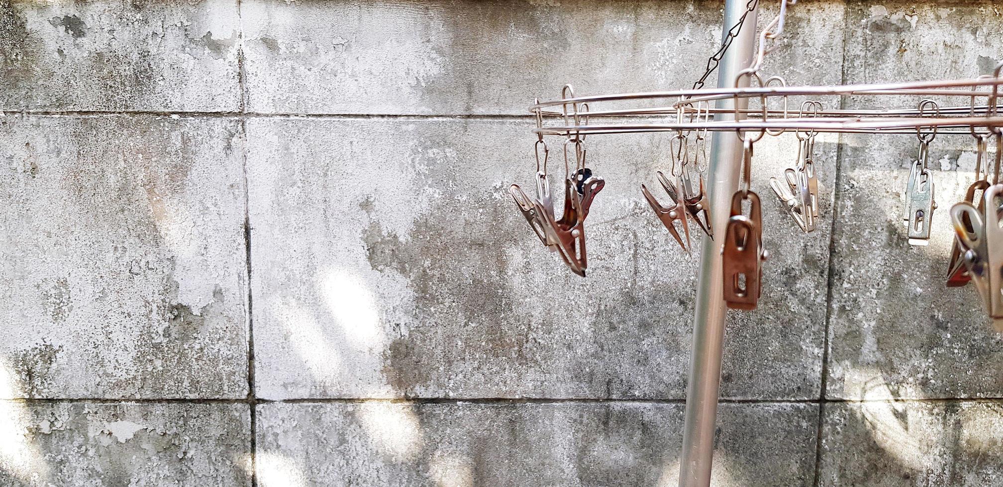 Stainless steel clothespin for hanging cloth and fabric with rough concrete wall and copy space photo