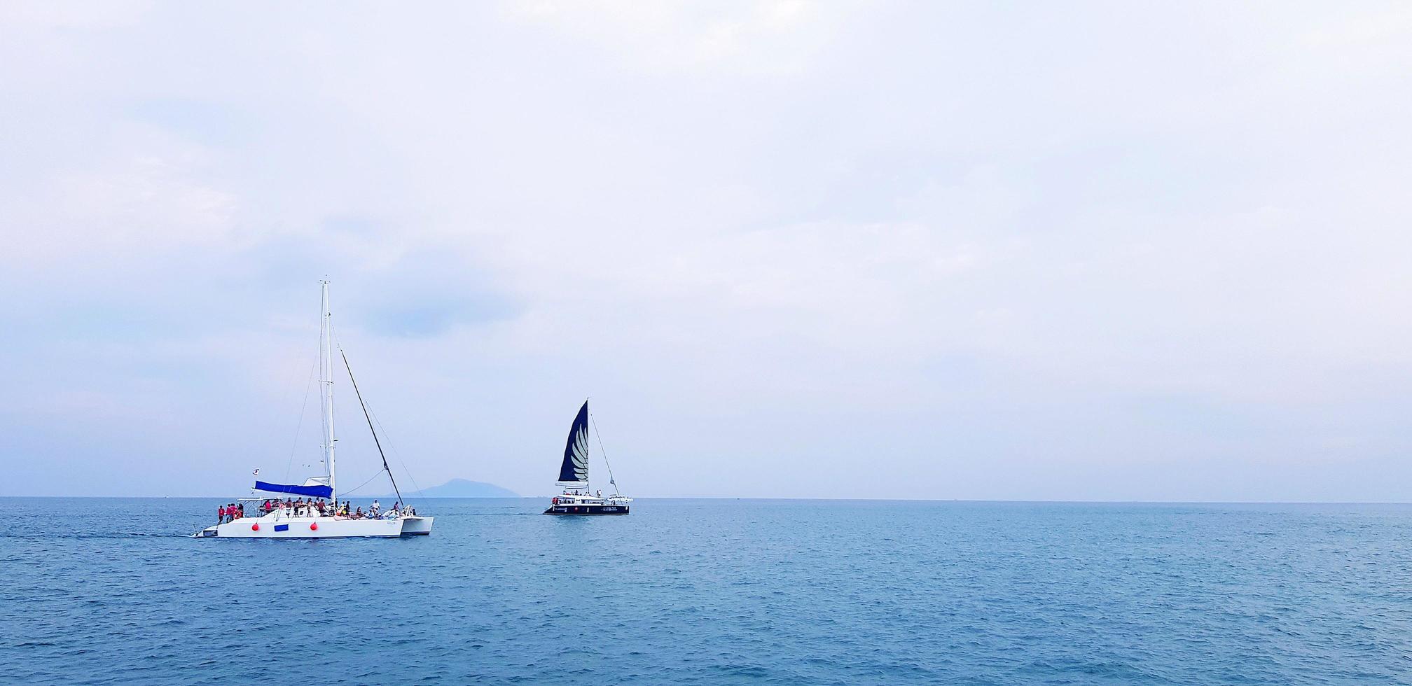 Sail and speed boat on sea with blue sky and cloud background with copy space. Group of tourist or people travel on ocean at Phuket, Thailand. Take a trip concept photo