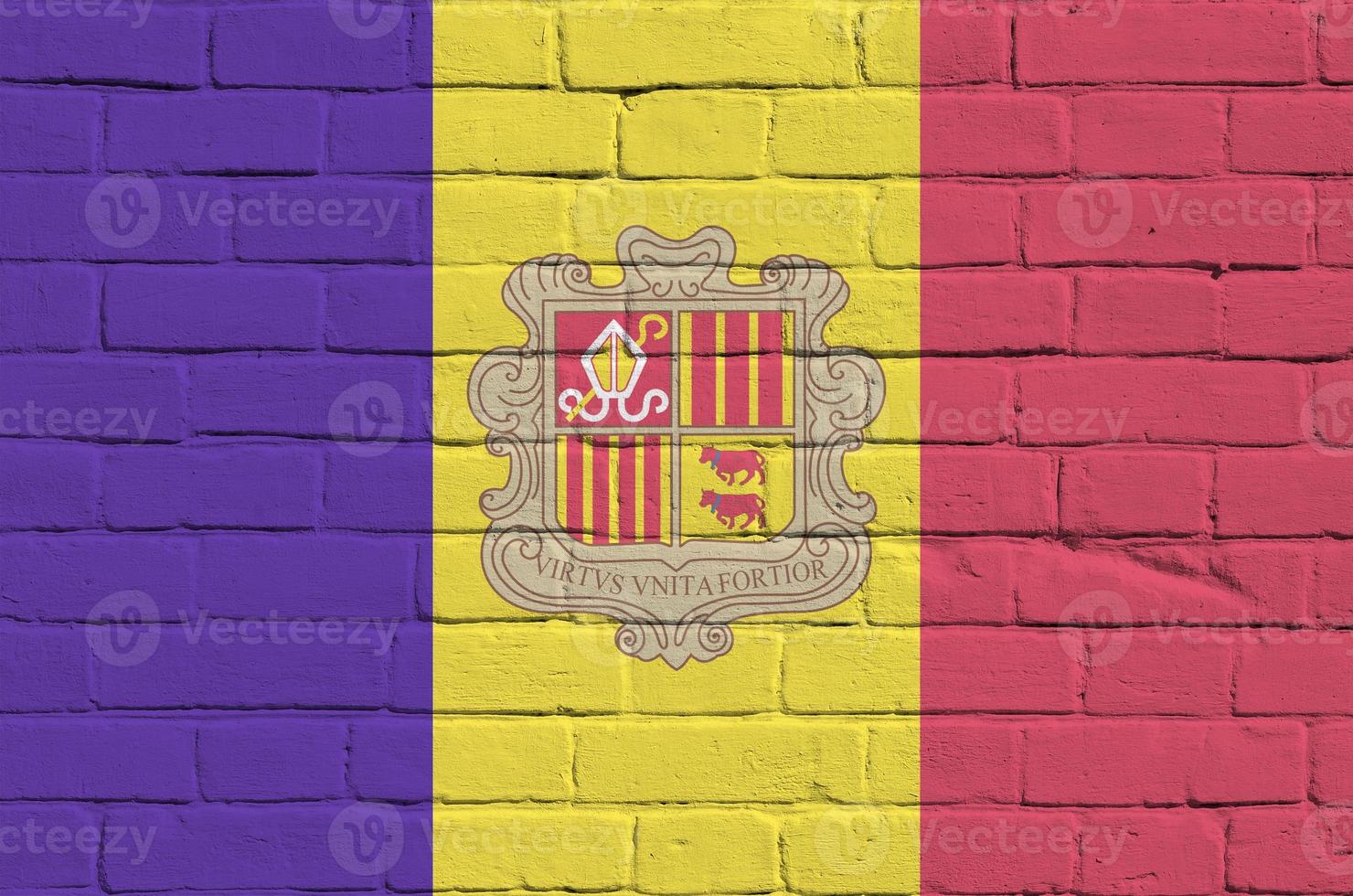 Andorra flag depicted in paint colors on old brick wall. Textured banner on big brick wall masonry background photo