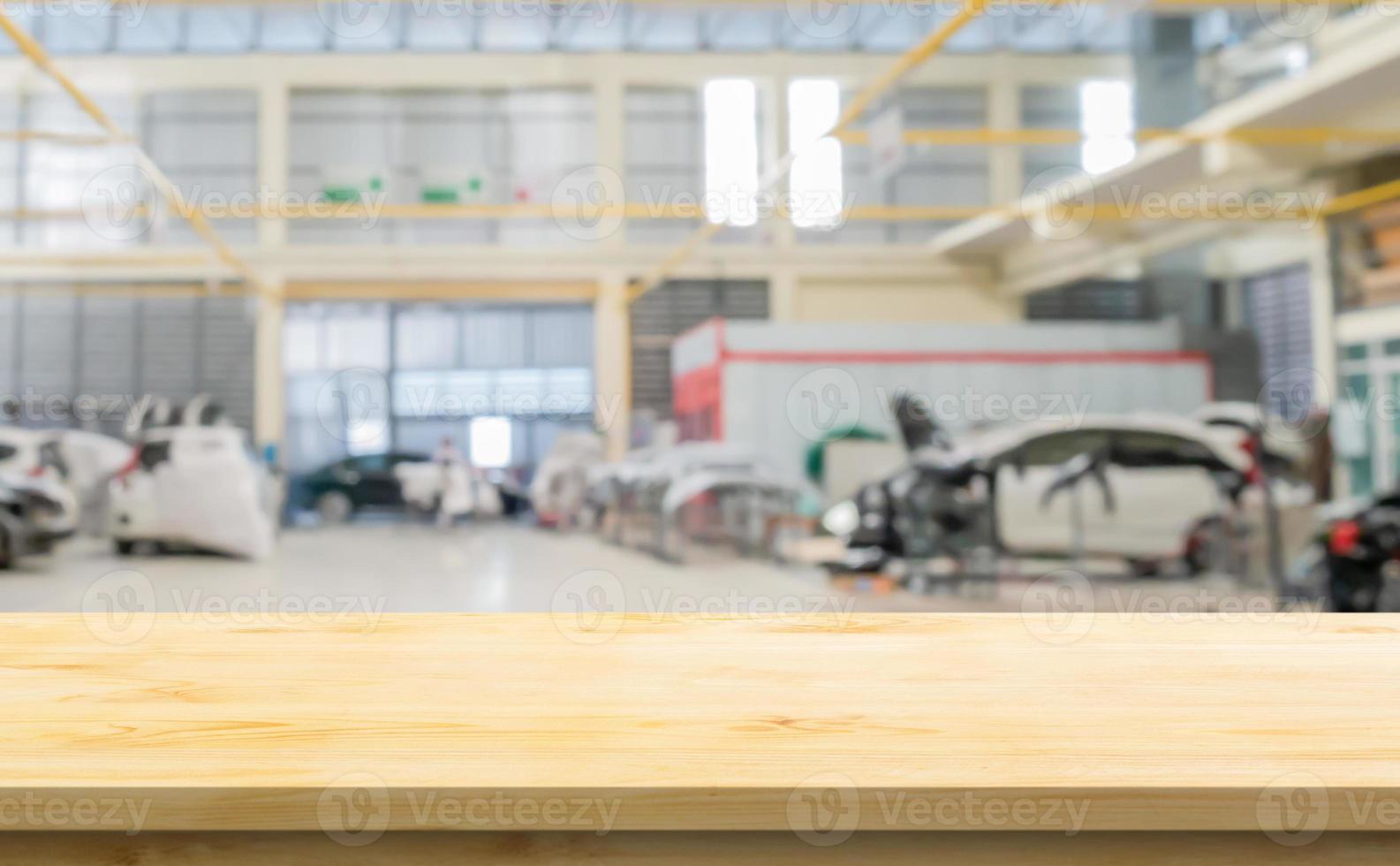 Empty wood table top with car service centre auto repair workshop blurred background photo