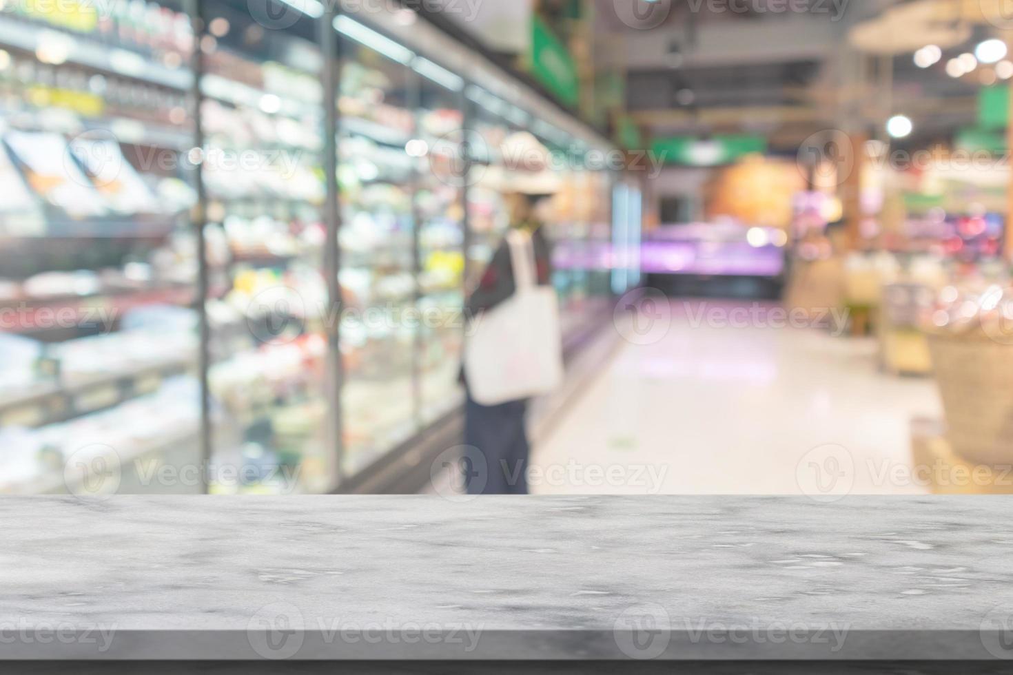 mesa de mármol vacía con pasillo de supermercado y estantes de fondo borroso foto