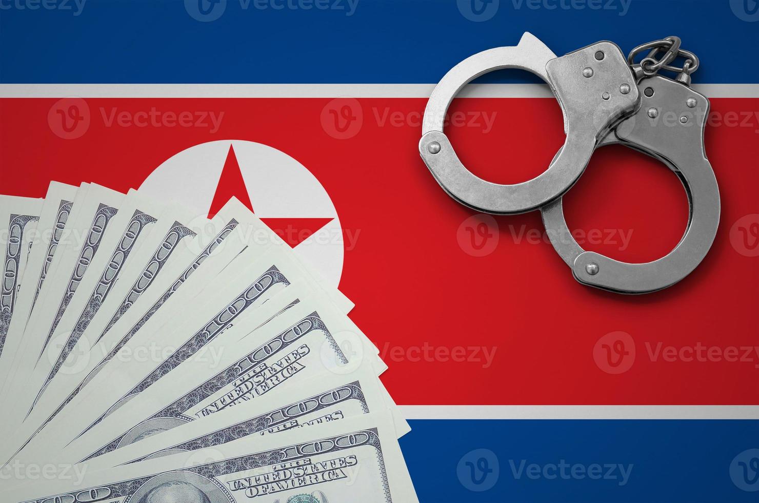 North Korea flag  with handcuffs and a bundle of dollars. The concept of illegal banking operations in US currency photo