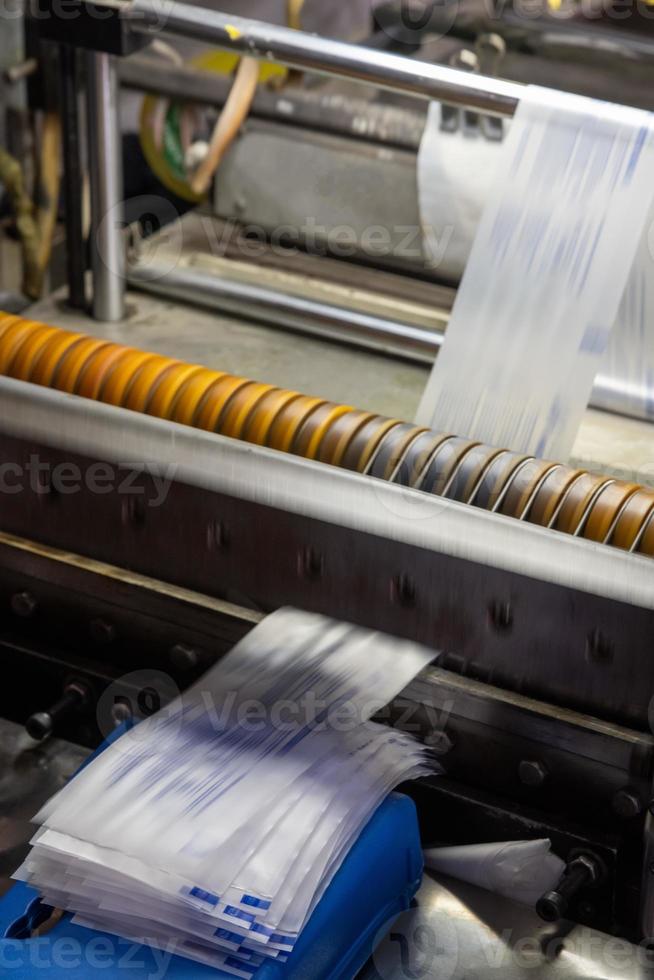 A vertical shot of a machine printing syringe labels at a medical production warehouse photo