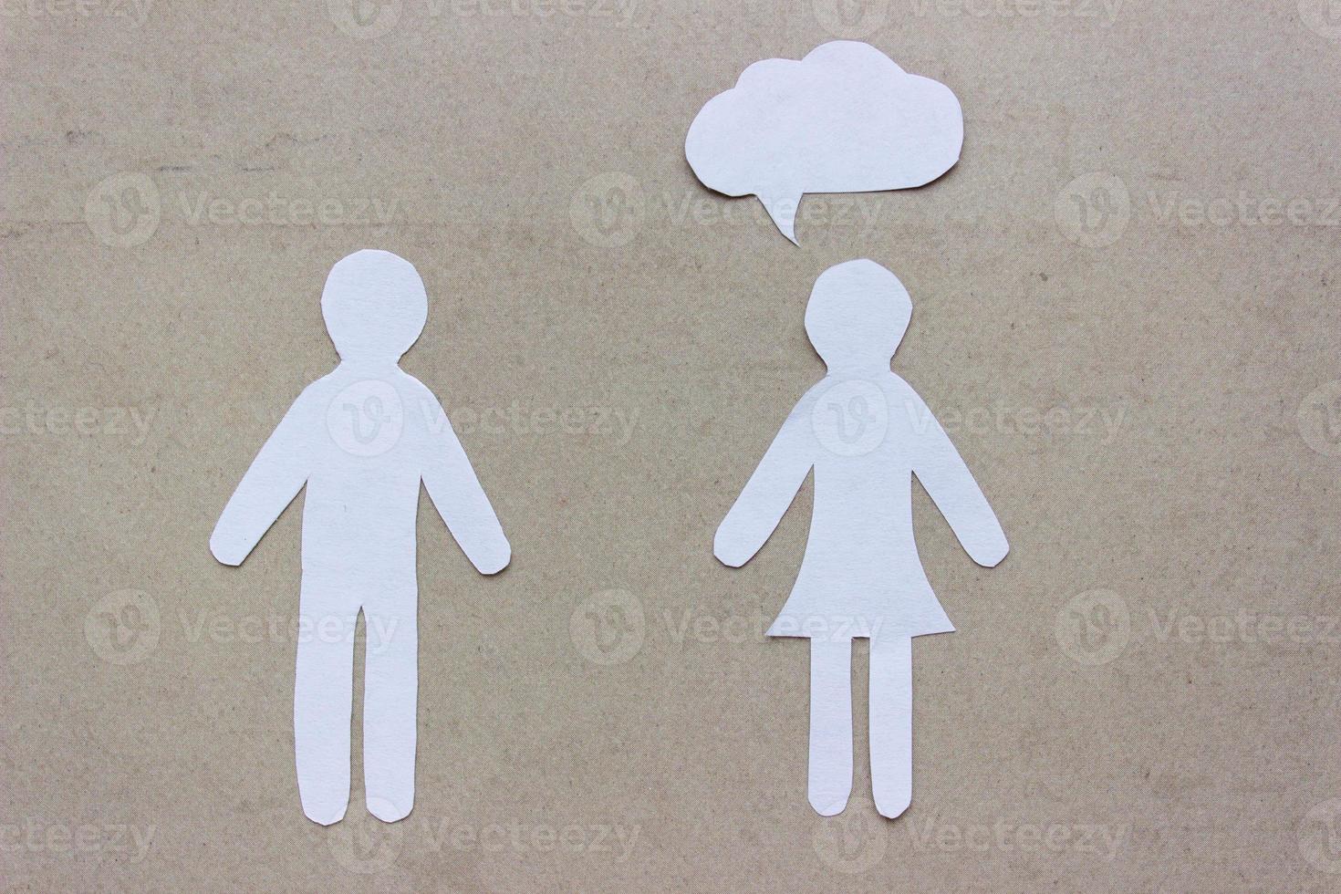 The silhouettes of a man and woman in a dress made of white paper, cut by hand. With speech-bubble over woman. photo