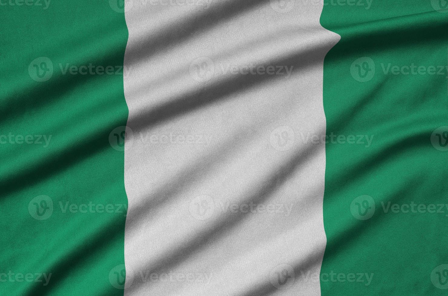 Nigeria flag  is depicted on a sports cloth fabric with many folds. Sport team banner photo