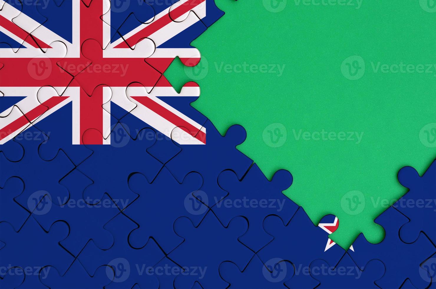 New Zealand flag  is depicted on a completed jigsaw puzzle with free green copy space on the right side photo