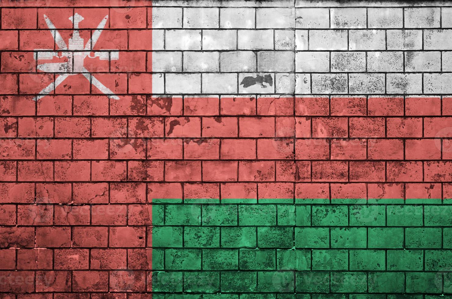 Oman flag is painted onto an old brick wall photo