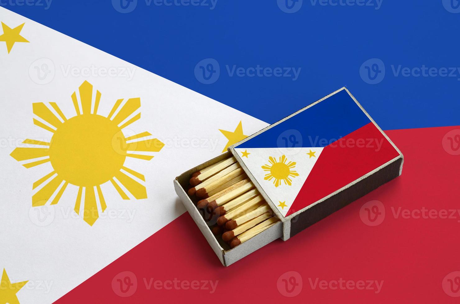 Philippines flag  is shown in an open matchbox, which is filled with matches and lies on a large flag photo