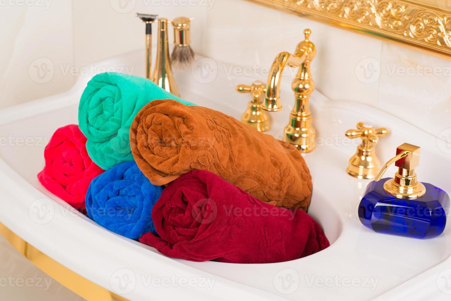 A closeup shot of rolled colorful bamboo towels in a sink in a bathroom photo