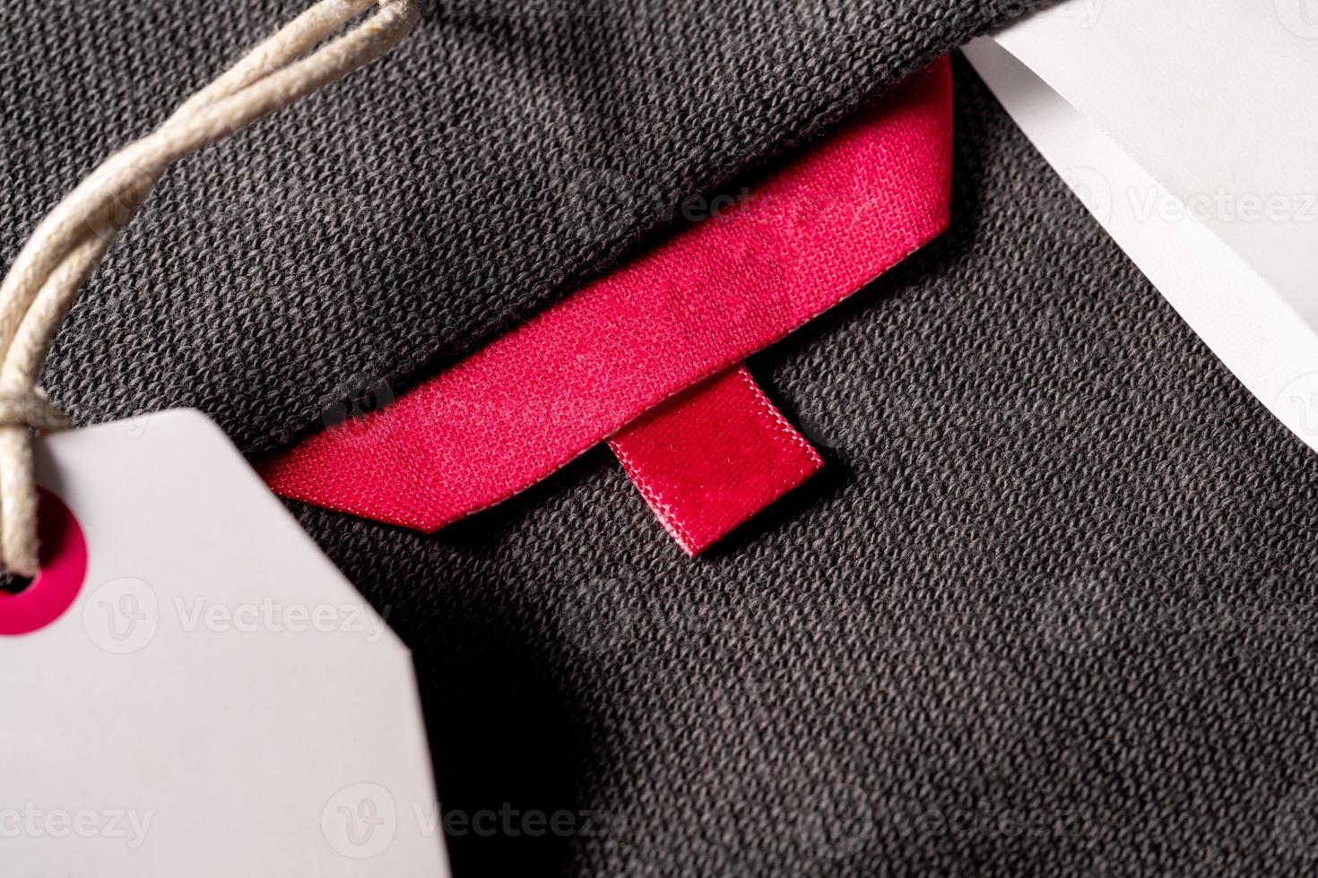 A closeup shot of a blank red fabric tag on a cloth for a size label photo
