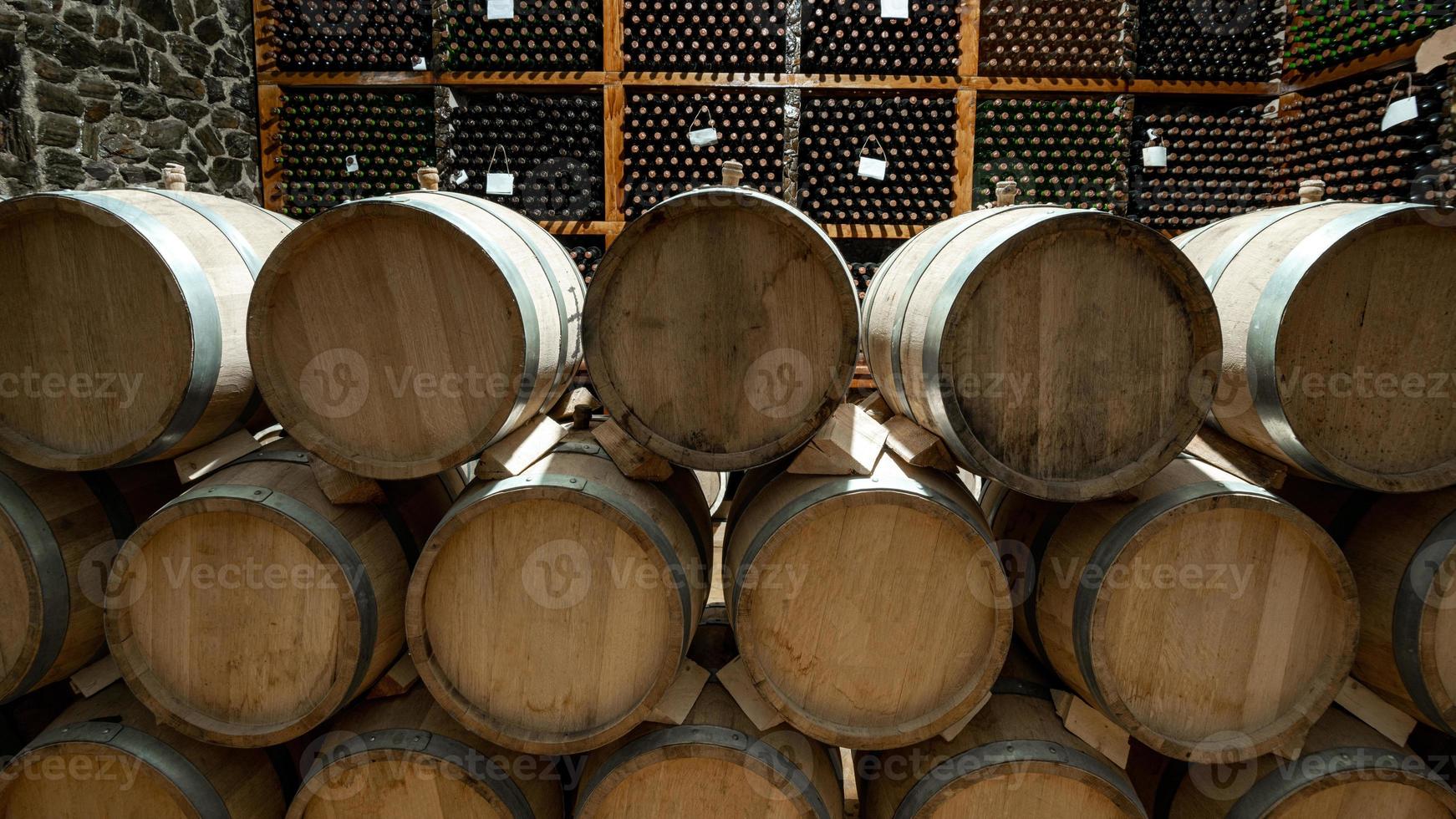 los barriles de vino de madera con una bodega al fondo foto