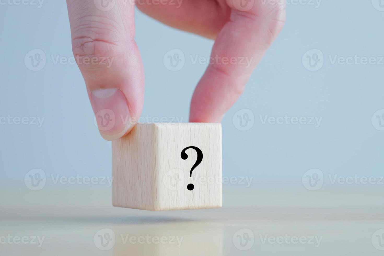 Hand holding question mark symbol on wooden block with copy space. Ask, FAQ, Advice, Support, Problem and solution concept. photo