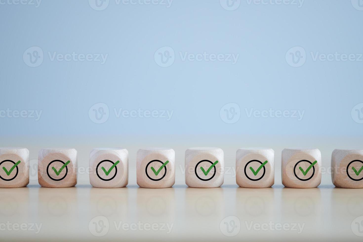 Checklist, Task list, Survey and assessment. Quality Control. Goals achievement and business success. Green check mark icon on wooden blocks. photo