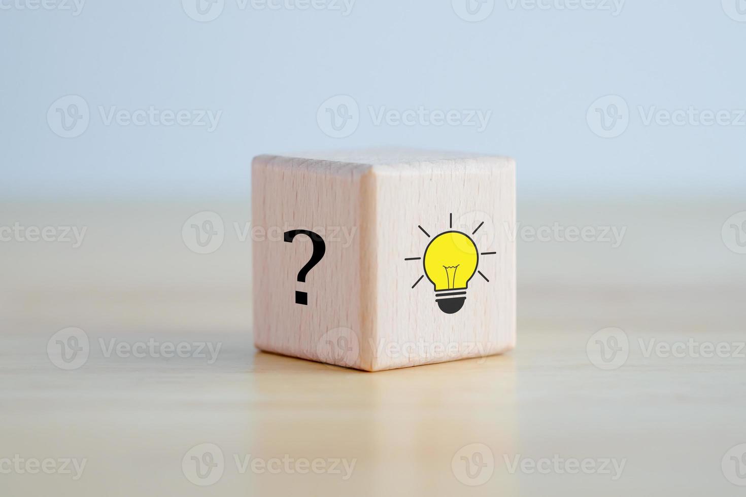 Idea and creativity concept. Creative process concept and problem solution. Glowing light bulb idea and question mark on wooden block. photo