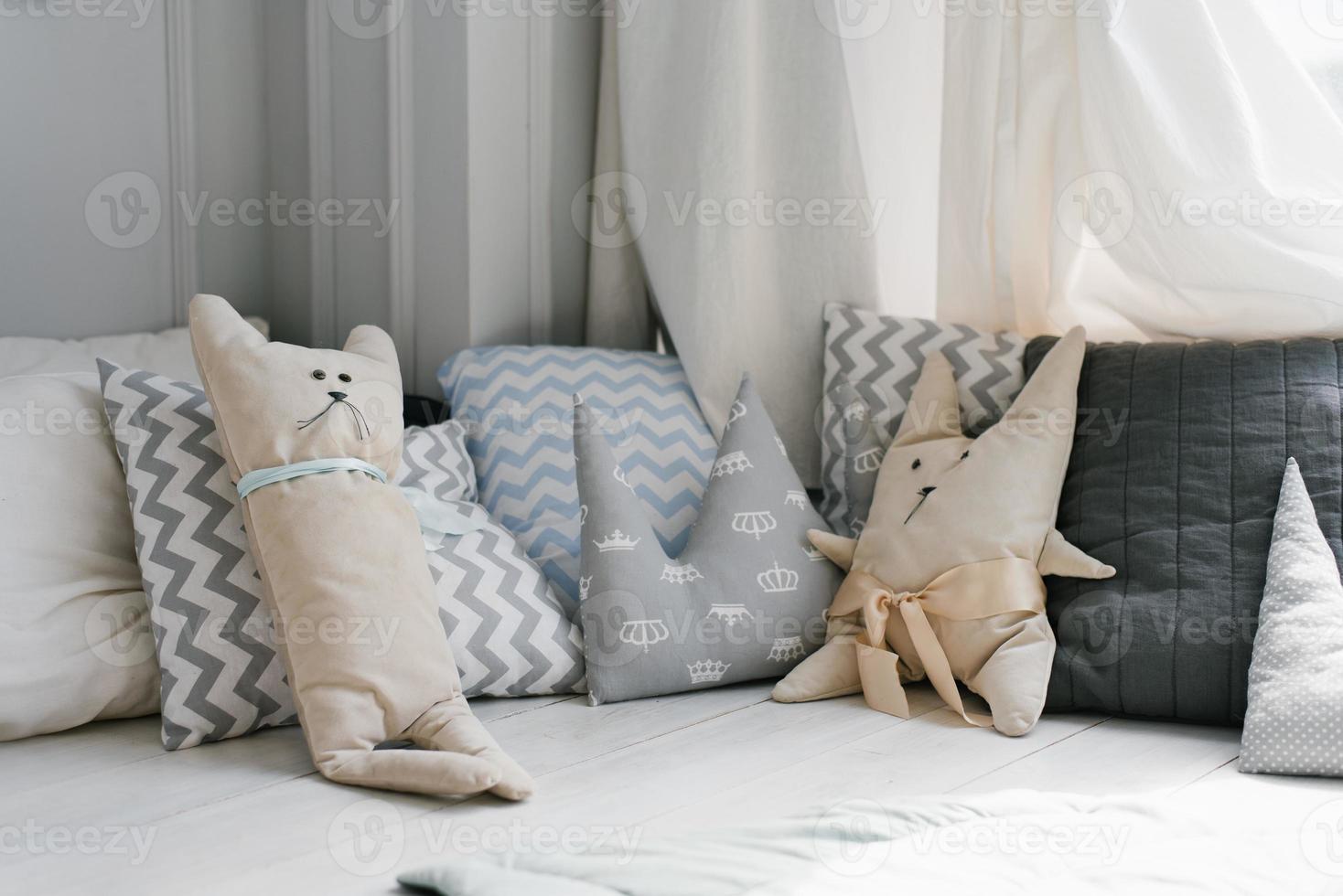 coloridos cojines infantiles en colores pastel. almohadas en forma de  conejito y oso en la cama de la habitación de los niños 13286356 Foto de  stock en Vecteezy