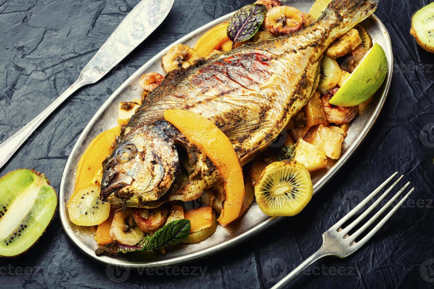 dorado de pescado al horno con piña, mango y kiwi. foto