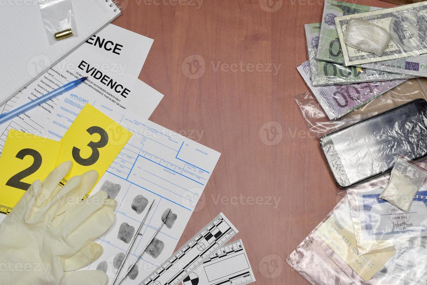 Paperwork during crime scene investigation process in csi laboratory. Evidence labels with fingerprint applicant and many confiscated personal items on wooden table photo