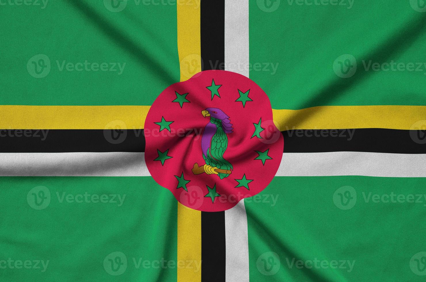 Dominica flag  is depicted on a sports cloth fabric with many folds. Sport team banner photo