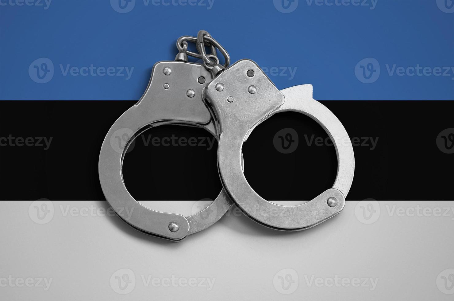 Estonia flag  and police handcuffs. The concept of observance of the law in the country and protection from crime photo