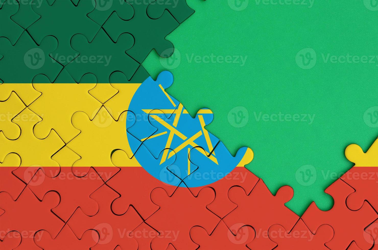 Ethiopia flag  is depicted on a completed jigsaw puzzle with free green copy space on the right side photo