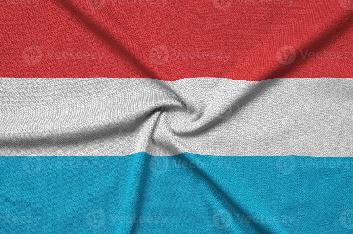 Luxembourg flag  is depicted on a sports cloth fabric with many folds. Sport team banner photo