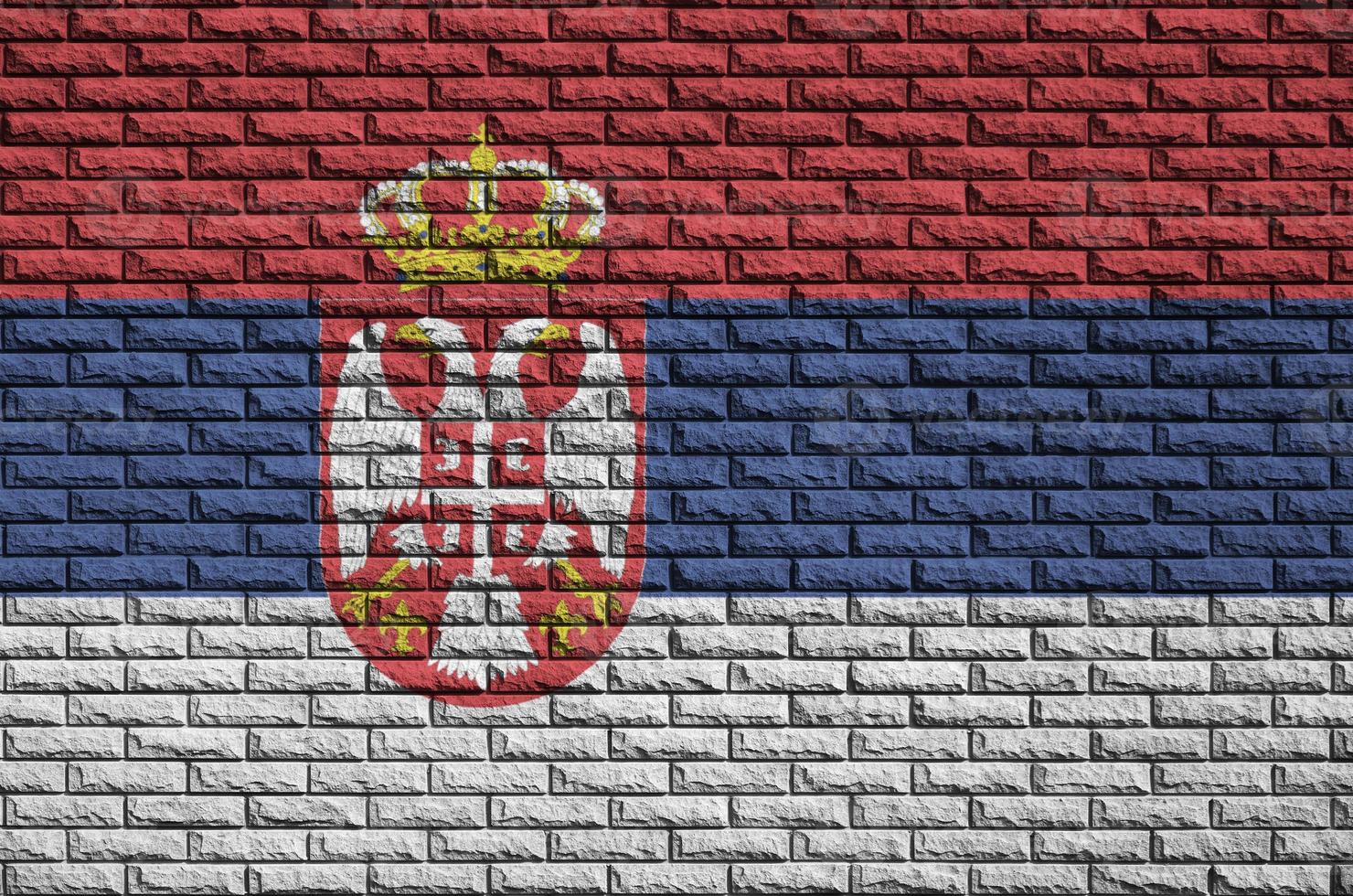 Serbia flag is painted onto an old brick wall photo