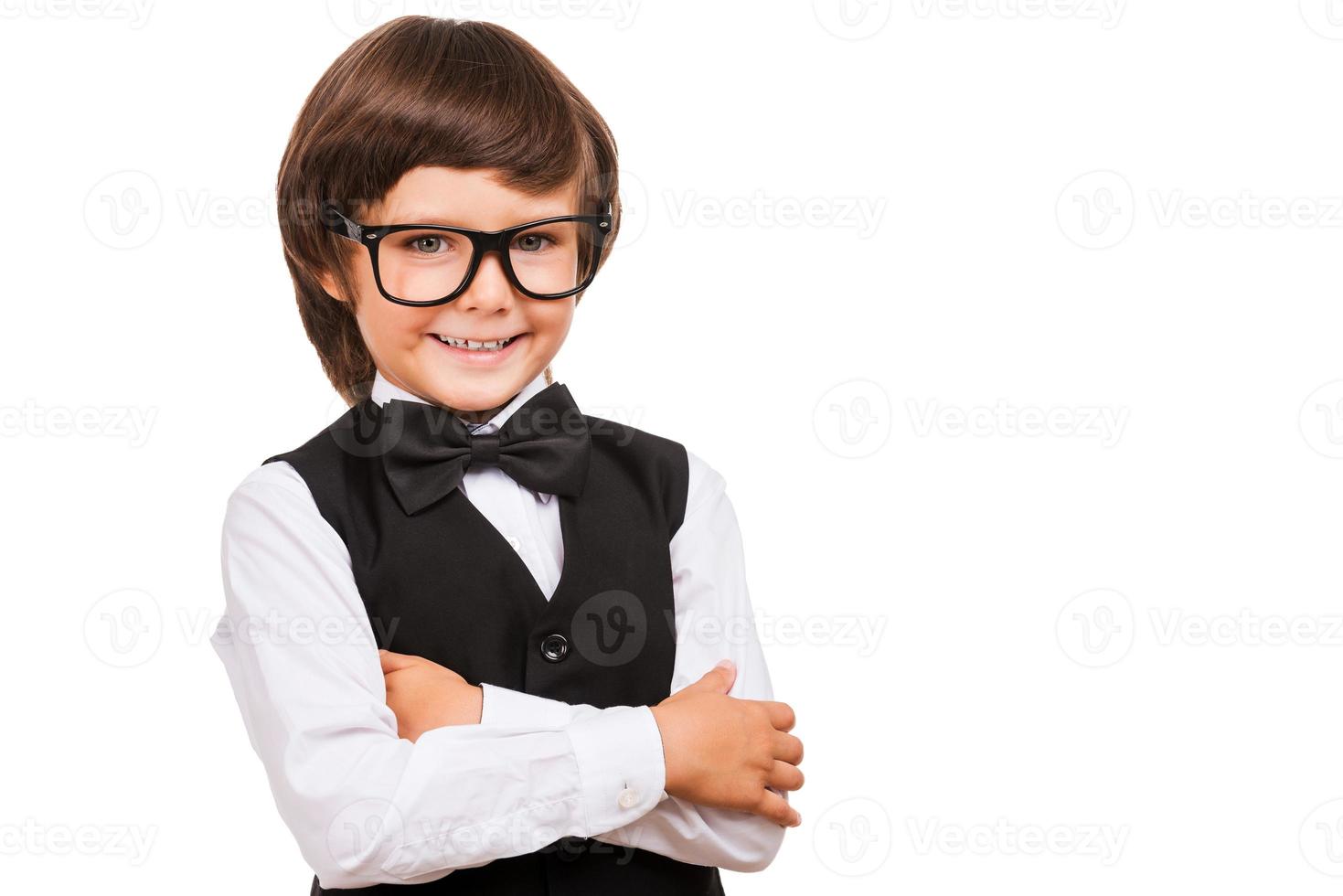 I know a lot of things. Portrait of young boy in bow tie looking at camera and smiling while isolated on white photo